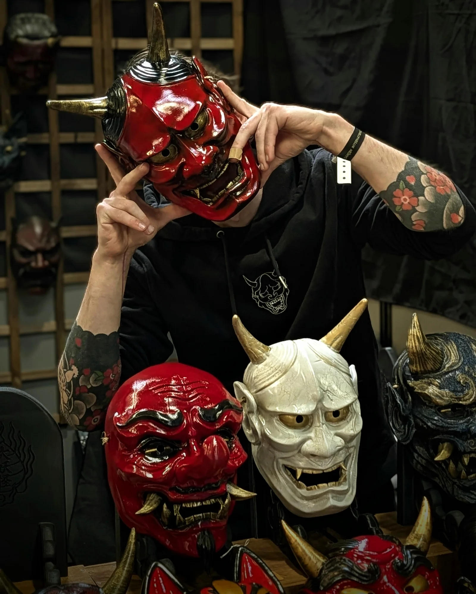 Red Dai Yokai Hannya mask worn, with several Japanese masks displayed in front.