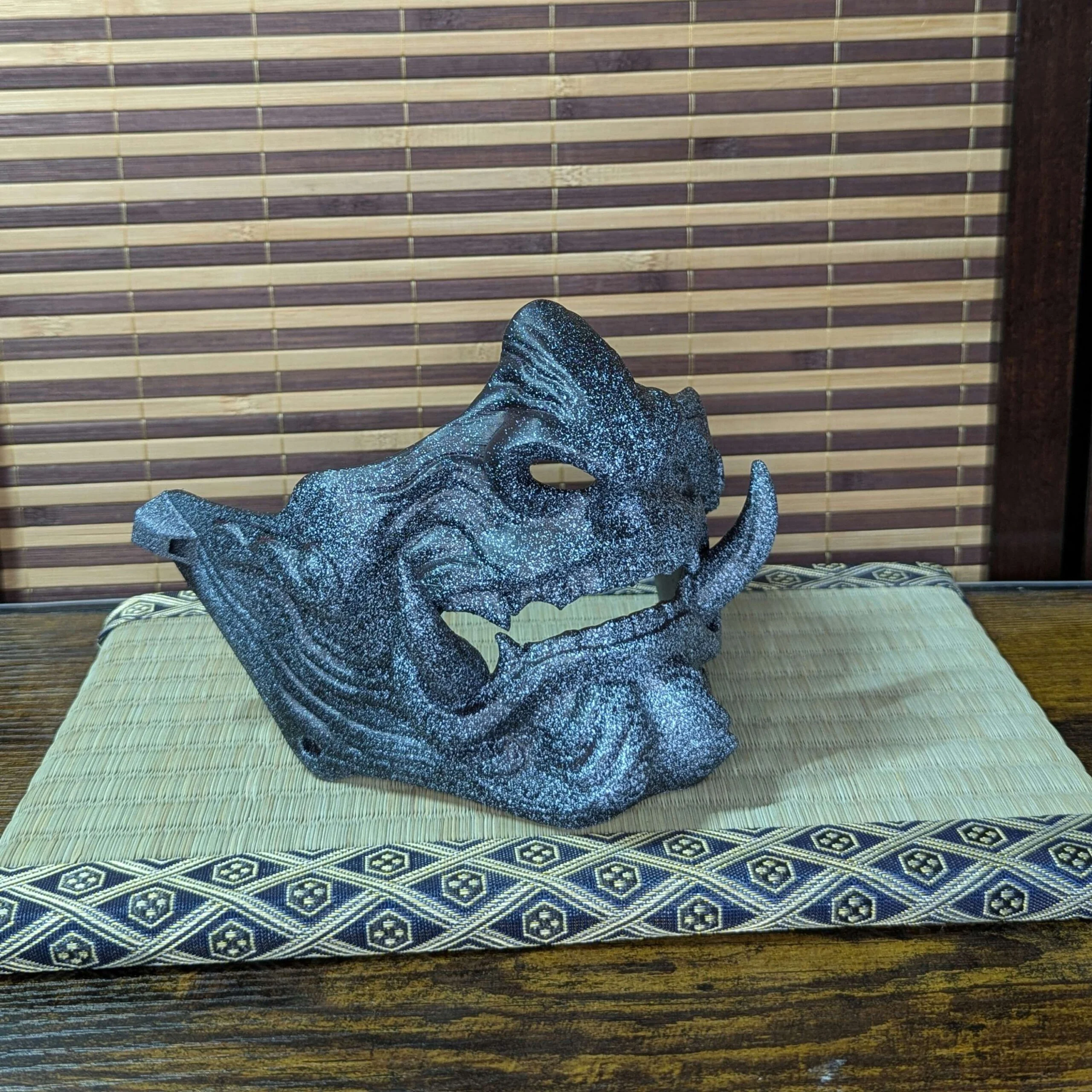 Demi-masque Mempo Oni Ao bleu en détail, peinture noire et bleue.