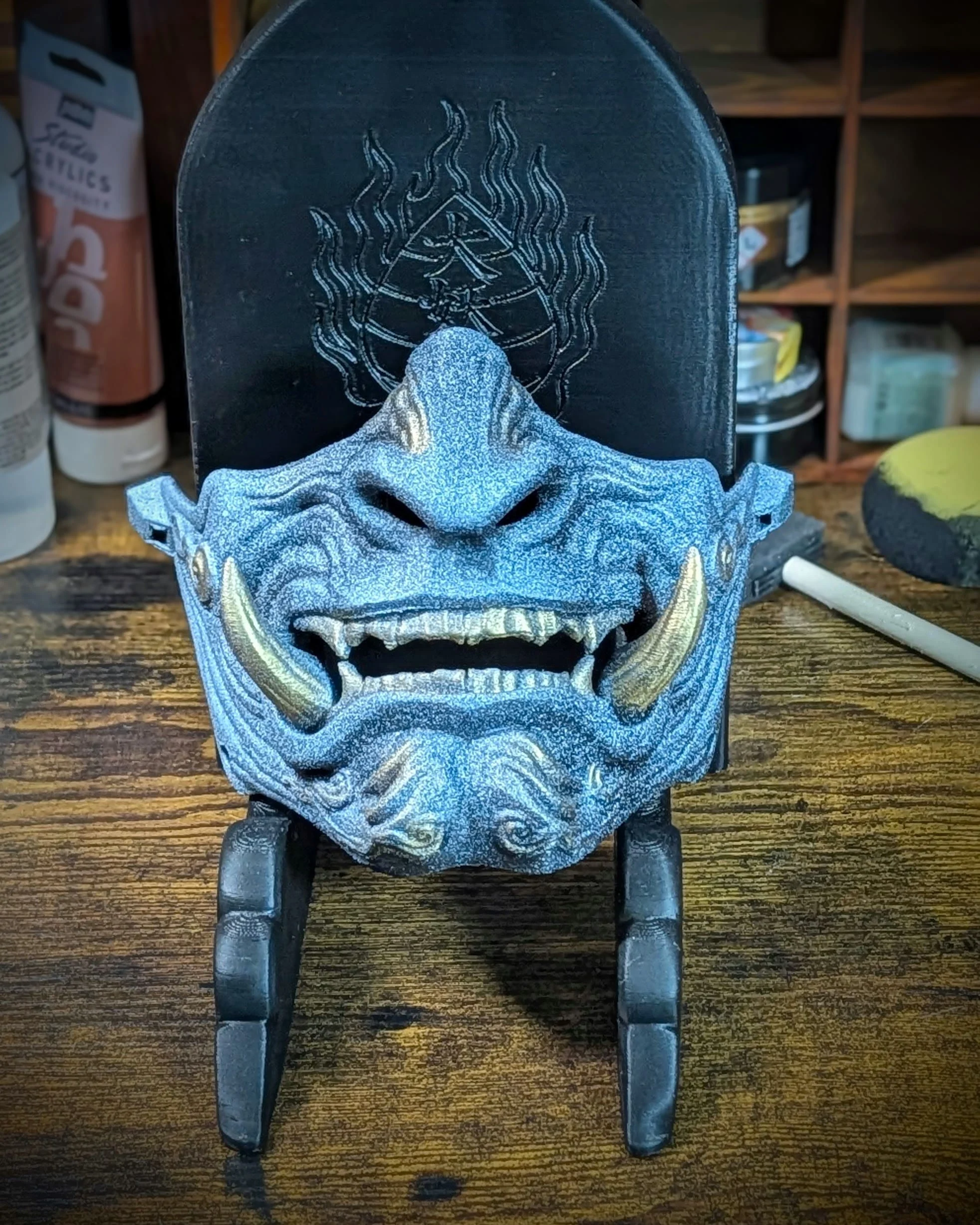 Demi-masque Mempo Oni Ao bleu tenu en main, format cosplay et exposition.