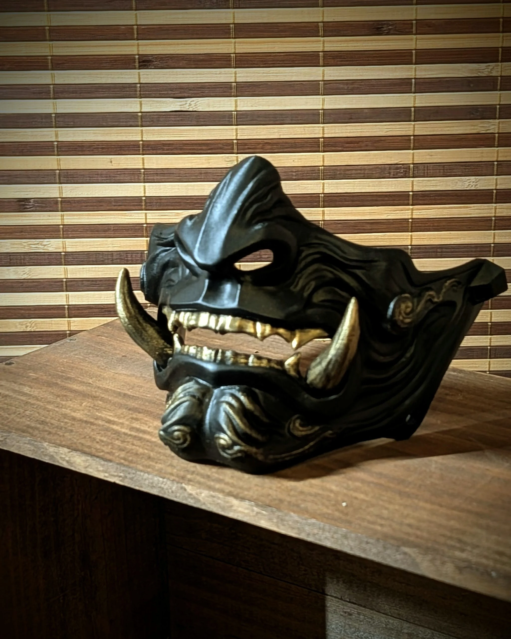 Demi-masque Mempo Oni Kuro noir en vue trois quarts.