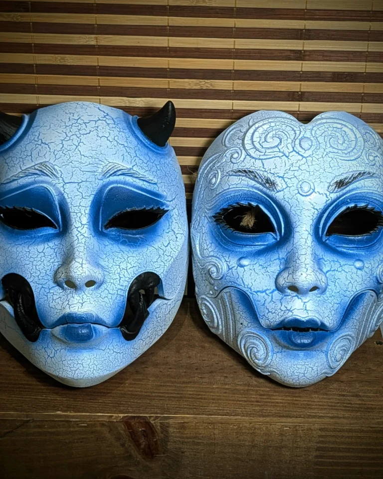 Masques Geisha et Kuchisake version Yuki-onna bleu vus de face, peinture craquelée blanche et bleue.