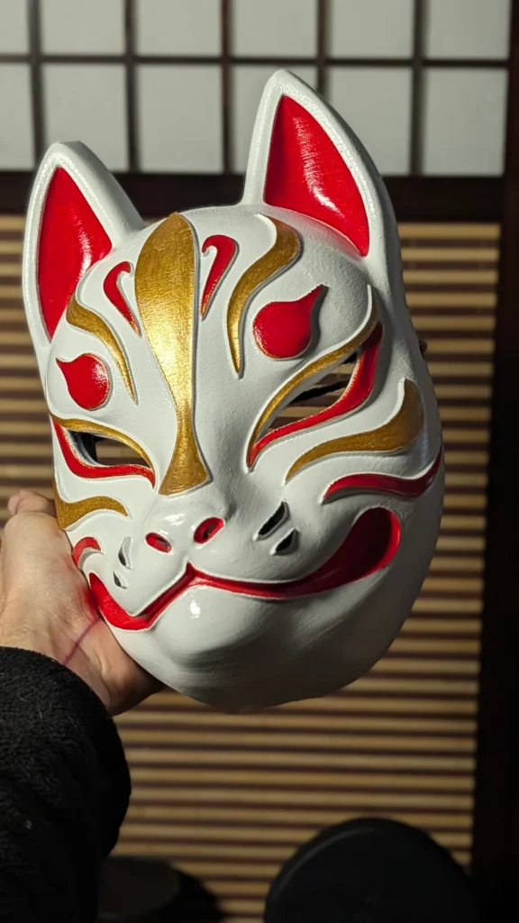 Masque de renard japonais Kitsune blanc et or tenu en main, finition vernis brillant fait main, Dai Yokai