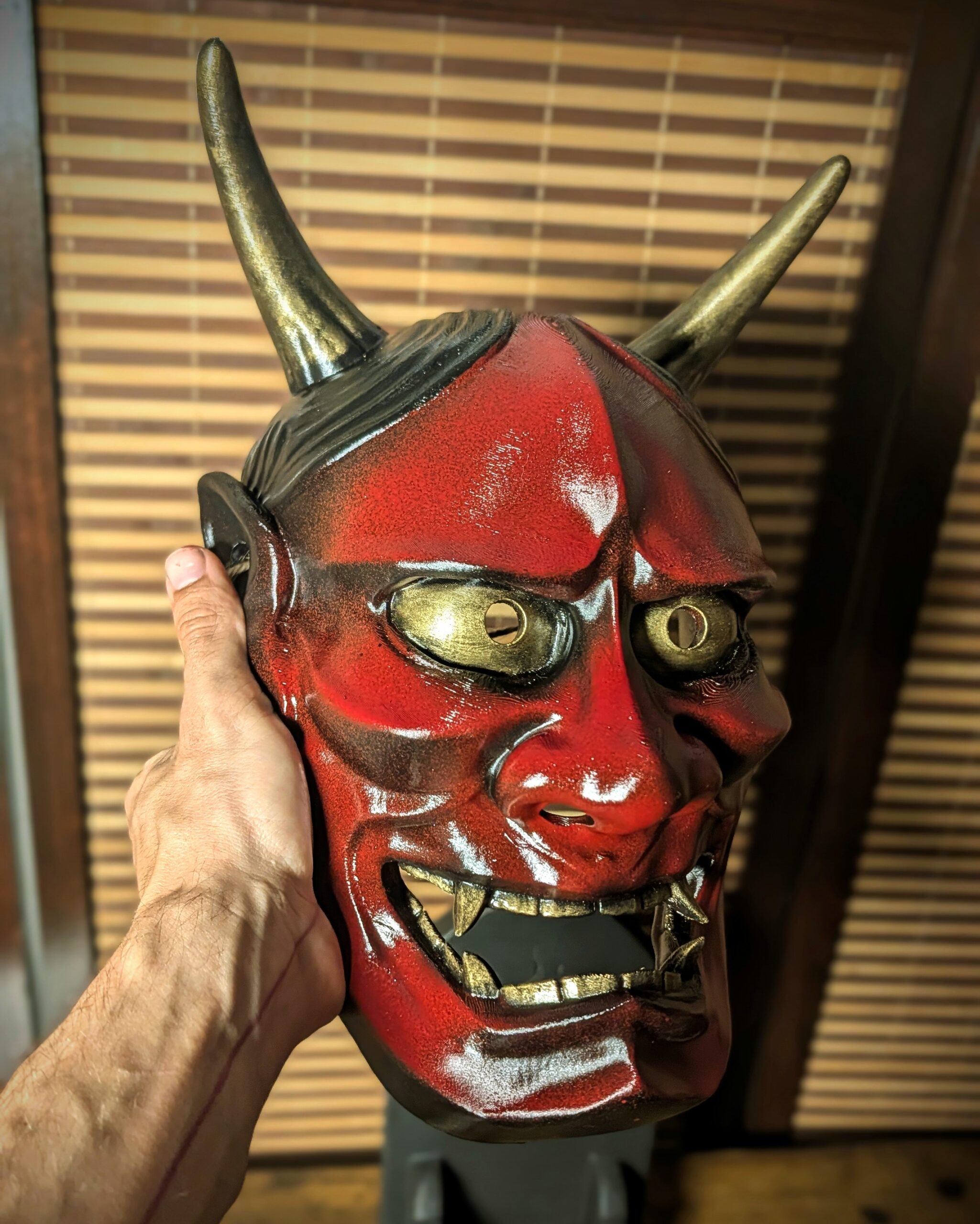 masque Hannya rouge traditionnel tenu main vue 3/4 Dai Yokai