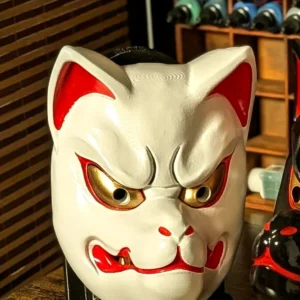 Masque Kitsune blanc traditionnel vu de face, finition blanche avec accents rouges et dorés.