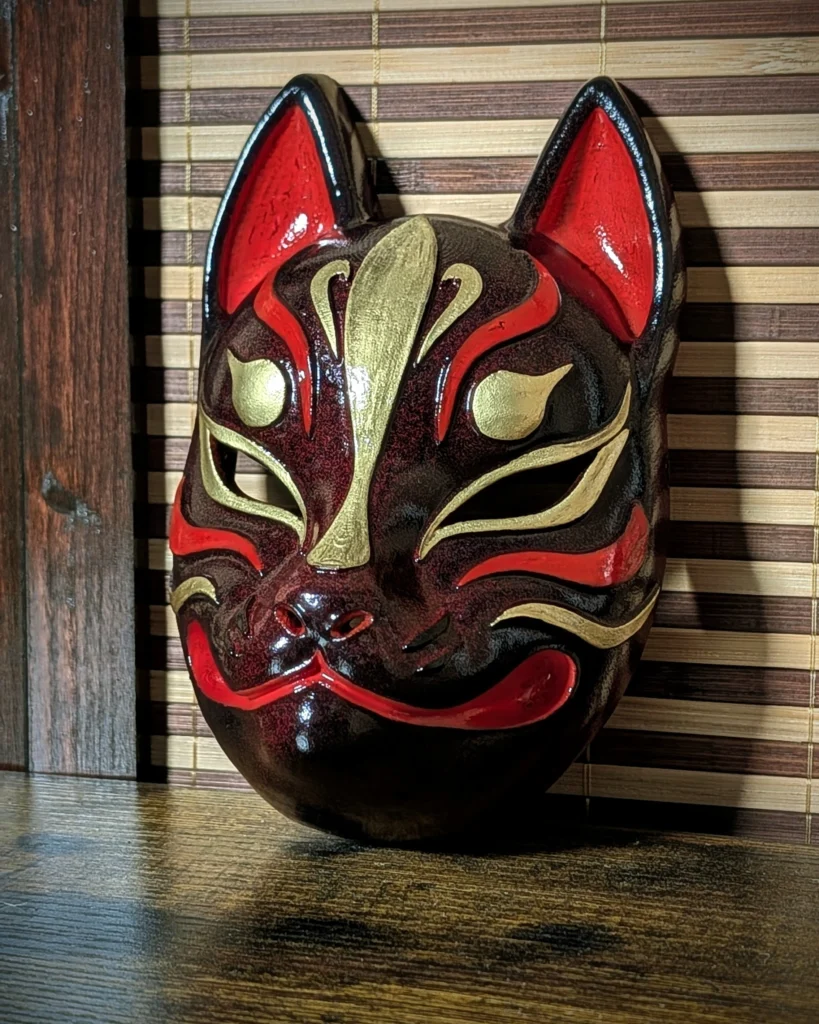 Masque Kitsune bordeaux moderne vu de profil, peinture acrylique or et rouge sur PETG, création Dai Yokai Bretagne