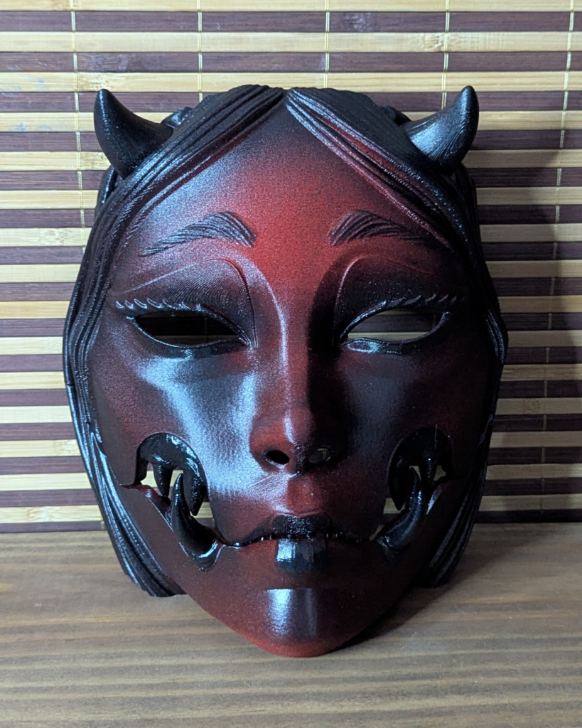 Masque articulé Kuchisake Onna avec longs cheveux noirs intégrés. Peinture faite main style horreur gore.