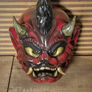 Masque oni punk rouge et noir, face frontale, crête mohawk sculptée et yeux dorés, fabriqué en France par Dai Yokai